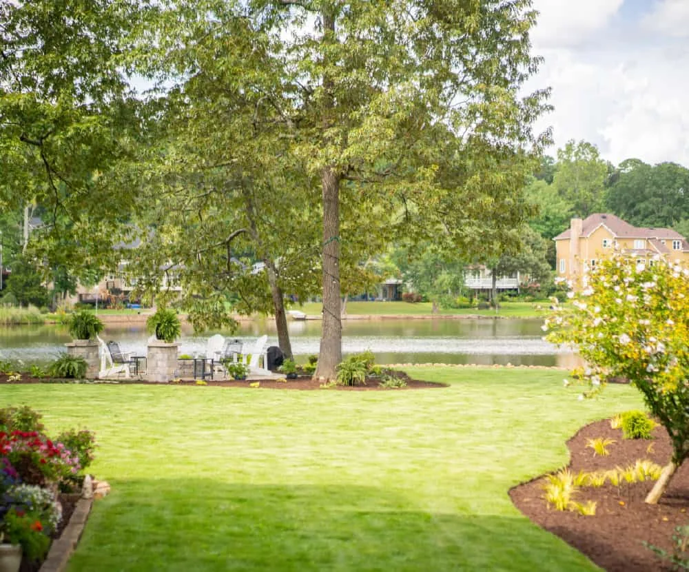 Lakeside backyard seating area with a lush lawn and pond view