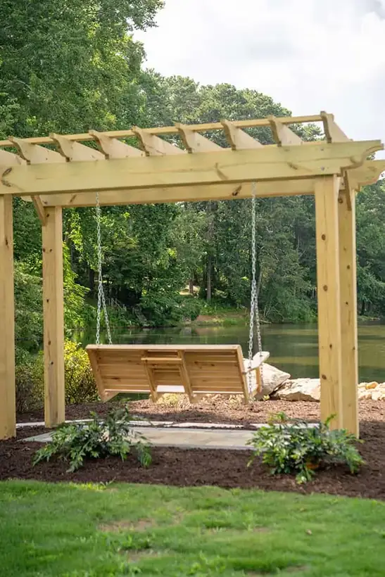 Cedar pergola with a porch swing overlooking the lake